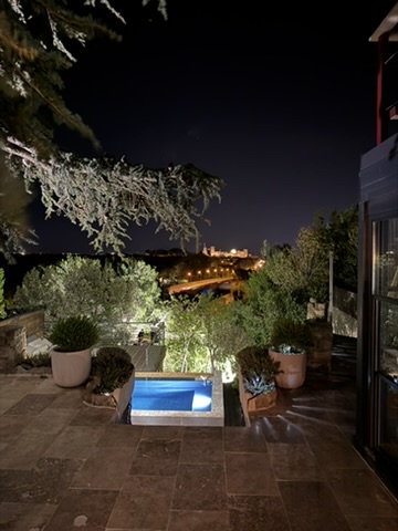 Piscine illuminée la nuit avec vue sur Avignon